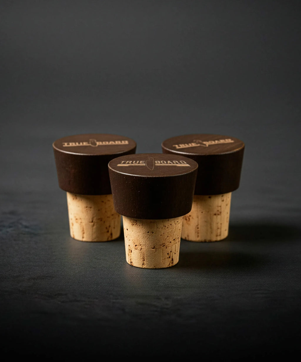 Three wine bottle corks with dark stoppers on a dark background