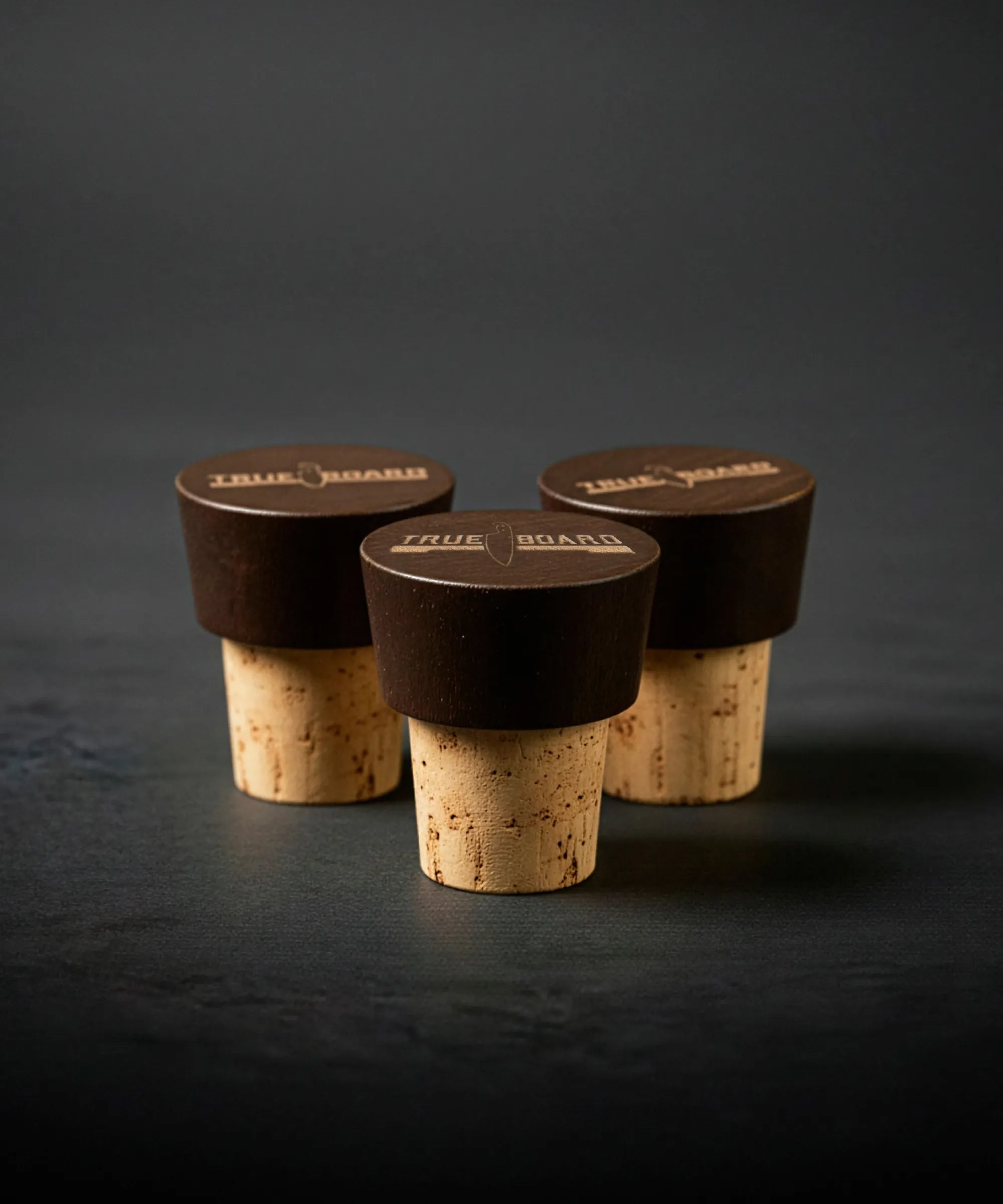 Three wine bottle corks with dark stoppers on a dark background