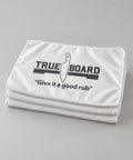 Three True Board towels folded and stacked, printed with the TRUE | BOARD logo