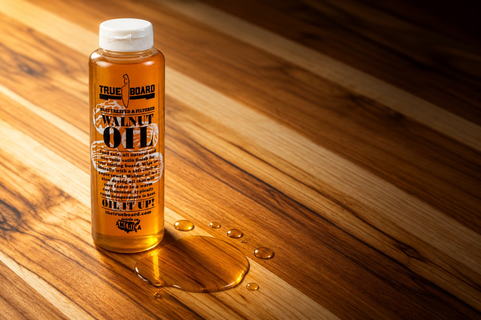 True Board walnut oil bottle standing on an oiled teak cutting board
