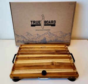 True Board carving setup with herbs and juices visible chef preparing ritual meal on wooden cutting board